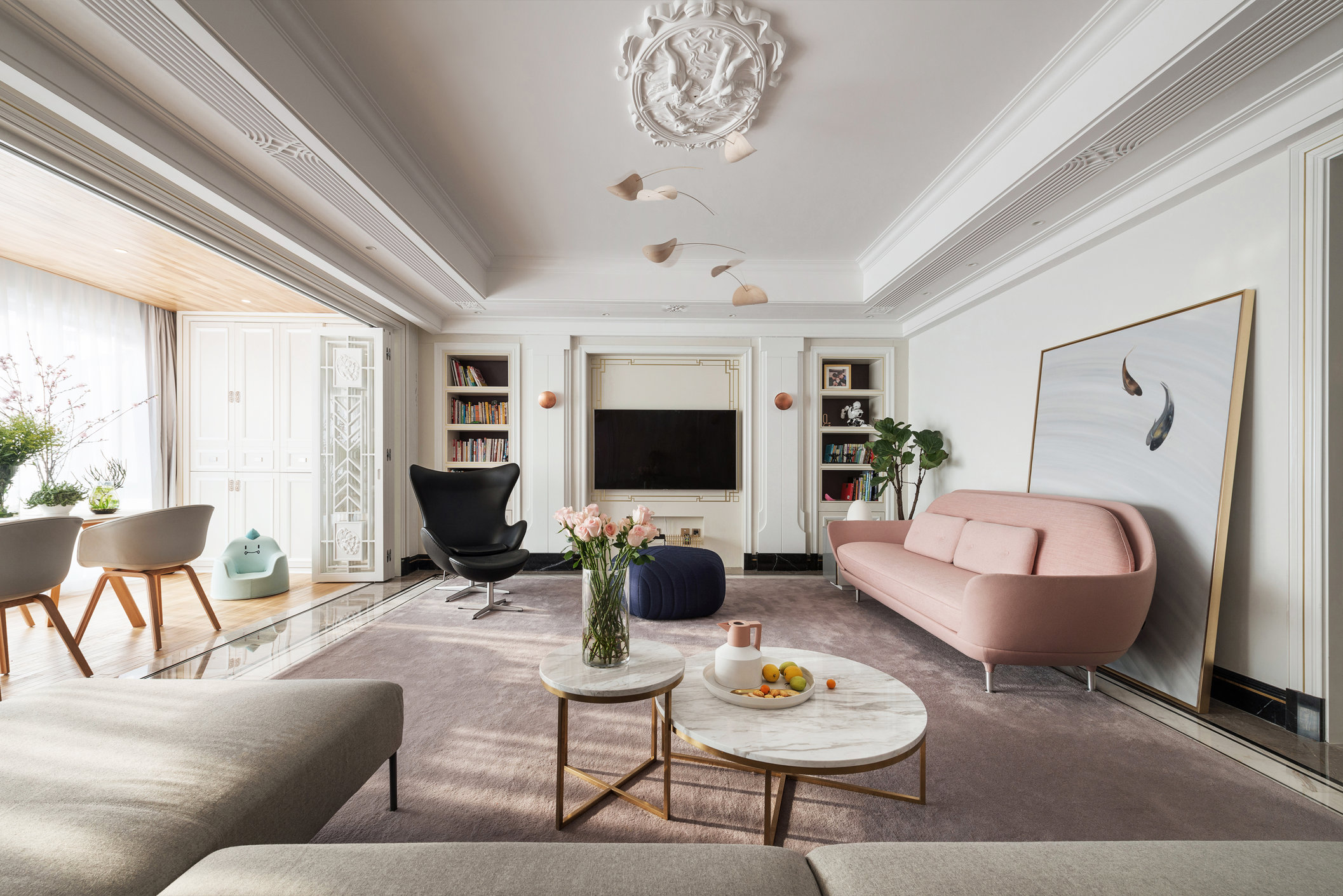 白色整个客厅设计，粉色沙发打破了原本冰冷的硬装，使客厅空间充满疗愈感。