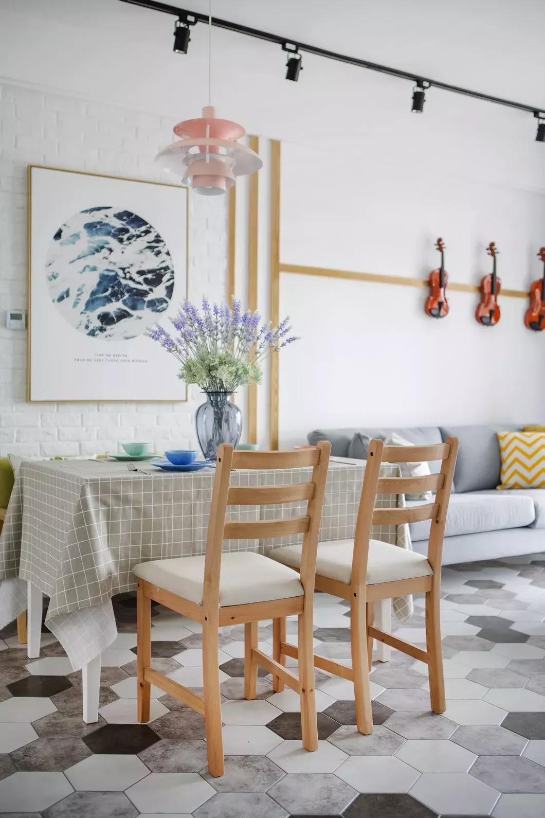 餐厅装饰画增添了空间的活跃气息，木色餐桌椅搭配格子桌布，让空间显得更加时尚高级。