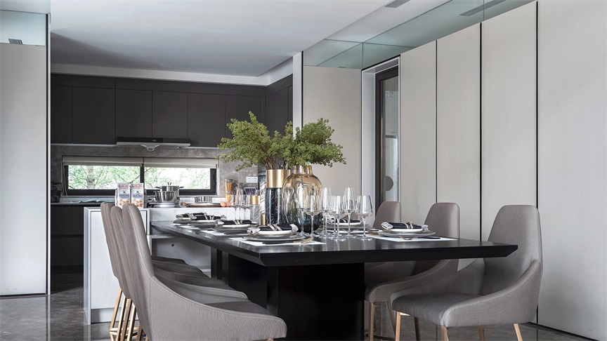 开放式厨房与餐厅相连，橱柜和餐椅都表现出，空间中灰色调占主导地位。