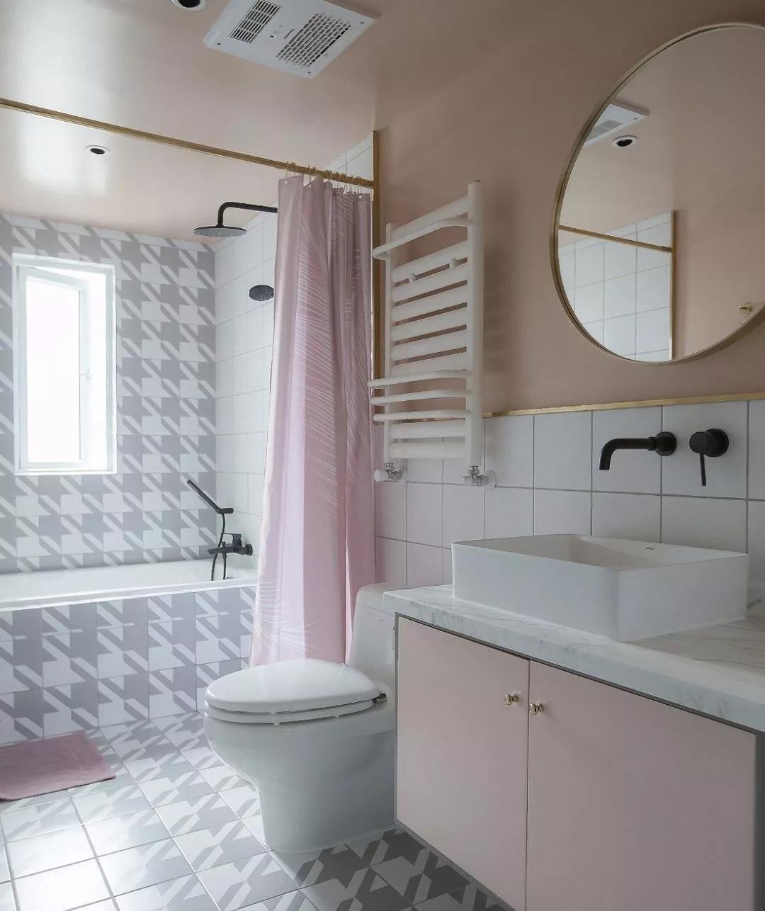 卫生间以粉色为主基调，浴缸采用同款色系铺贴，整体性强，局部使用浴帘做干湿分离。