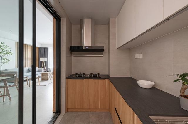 木色橱柜搭配深灰色工作台，构成简洁明亮，雅致整洁的烹饪空间。