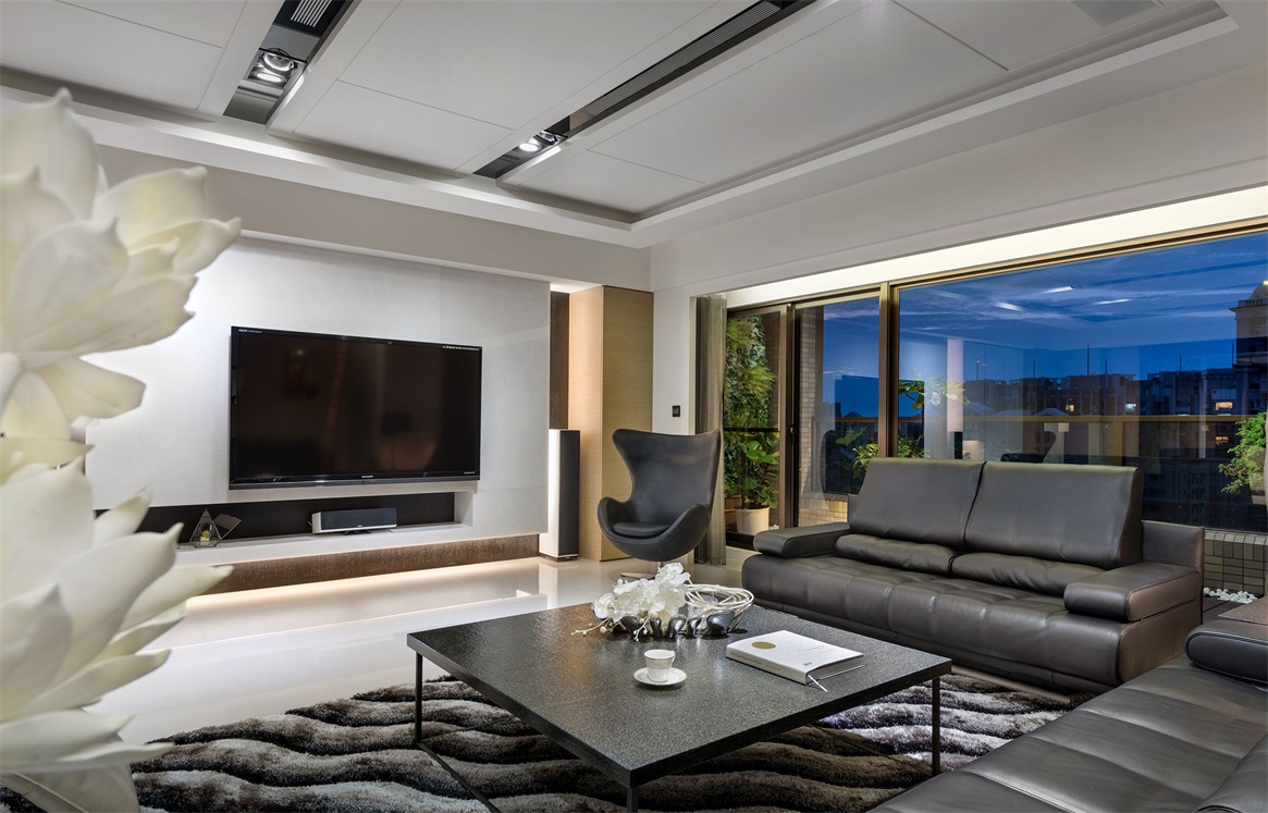 客厅空间设计师运用了深浅对比，黑色沙发与白色墙面形成视觉冲击。