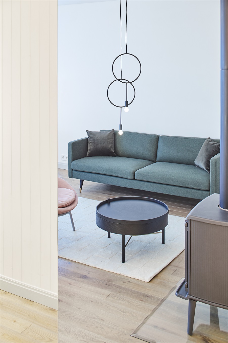 客厅背景墙采用白墙铺陈,配以墨绿色沙发,空间简单明亮,协调统一