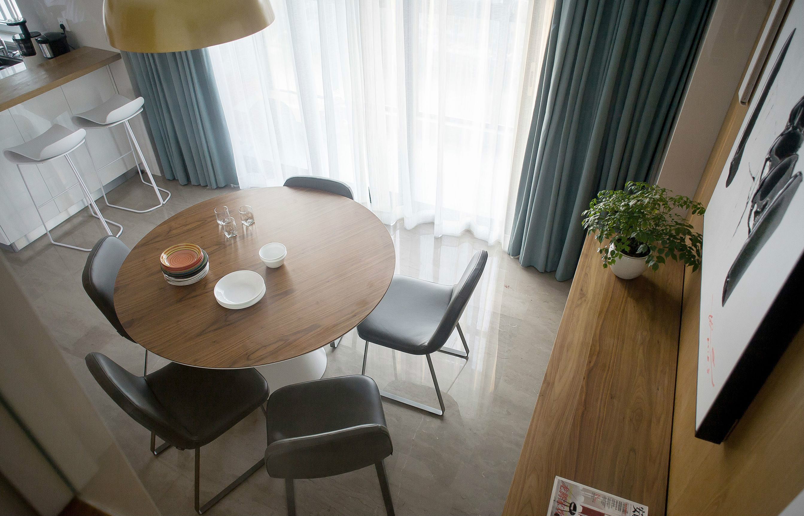 圆形餐桌搭配褐色餐椅，温馨有范儿，搭配装饰画和餐边柜，更好的释放了空间。