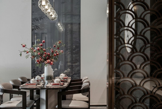 餐厅与客厅相连，以木色背景墙划分空间功能，中国风挂画与装饰营造中式用餐氛围。