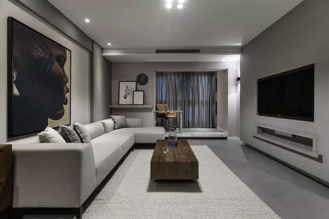 色调统一的客厅，家具整体色调为灰色.素色的布艺沙发与整个空间和谐搭配。