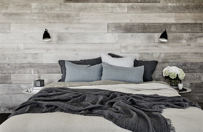 次卧背景采用木质元素铺贴，搭配灰白色床品，透露出业主的沉稳个性。