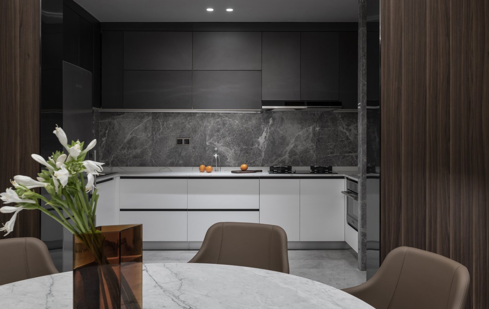 设计师将厨房设计为开放式厨房，灰白配色令空间处于安静而沉稳的氛围中。