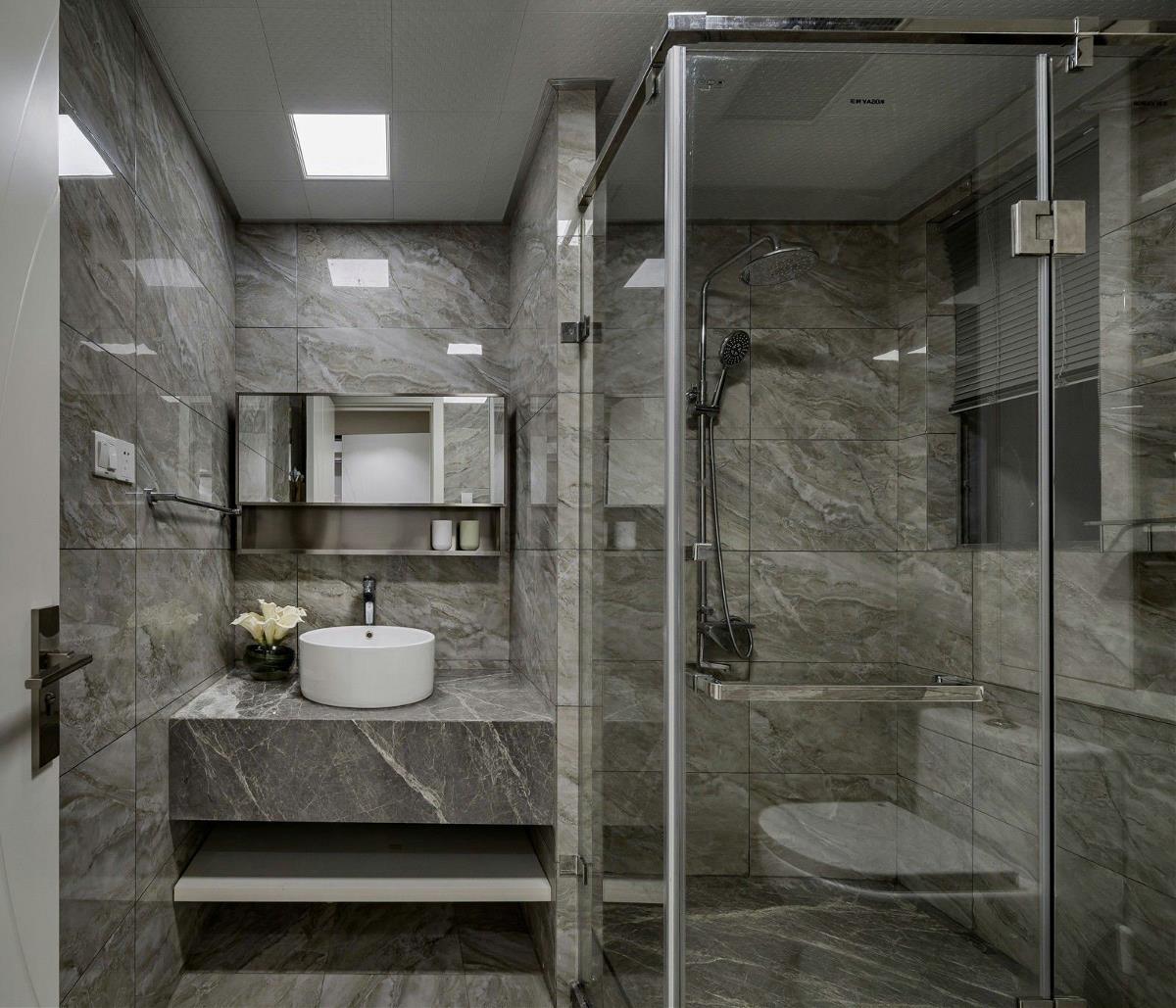 大理石的材质设计让卫生间显得十分简约，白色洁具的点缀彰显了空间的时尚特点。