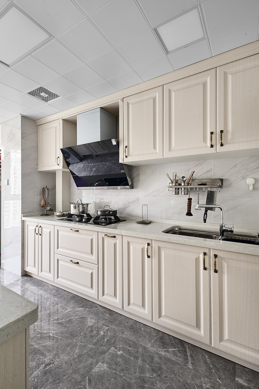 整个厨房采用线条勾勒，米白色橱柜简洁利落，呈现出开阔的视觉观感。