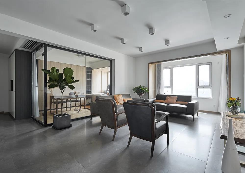 客厅空间划分巧妙，沙发后侧使用玻璃房打造办公区，提升空间的层次感。