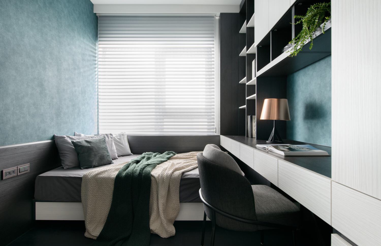 男孩房以蓝色为背景墙,使用榻榻米一体柜设计,空间利落而简洁.