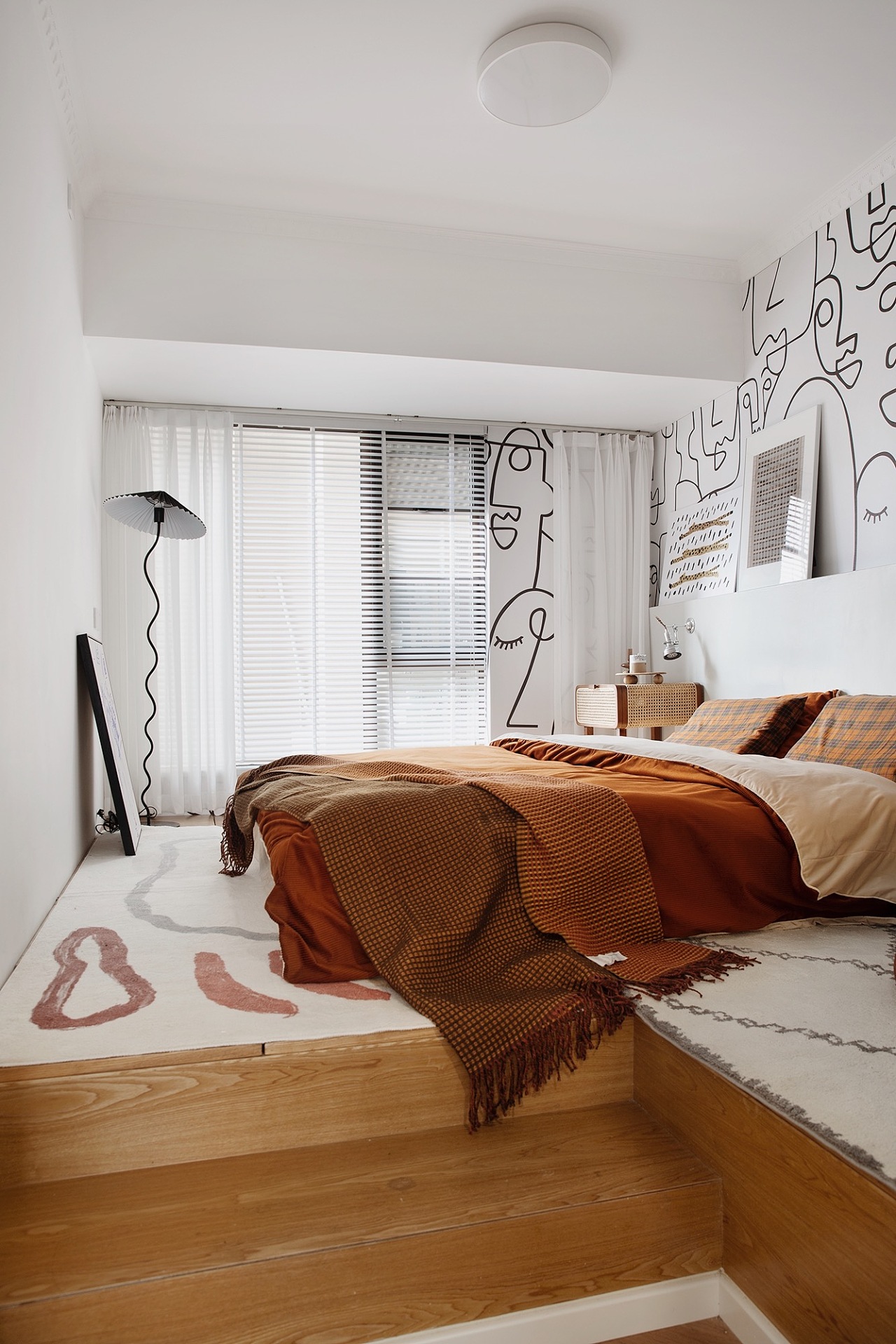 侧卧同样以橘色作为主题，白色背景墙卡通造型设计，橘色床品成为空间点缀。