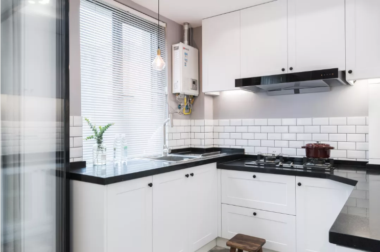 因为户型和空间的原因，厨房设计成了半包围的形式，呈U字型，黑色的大理石台面和白色的橱柜是经典搭配。