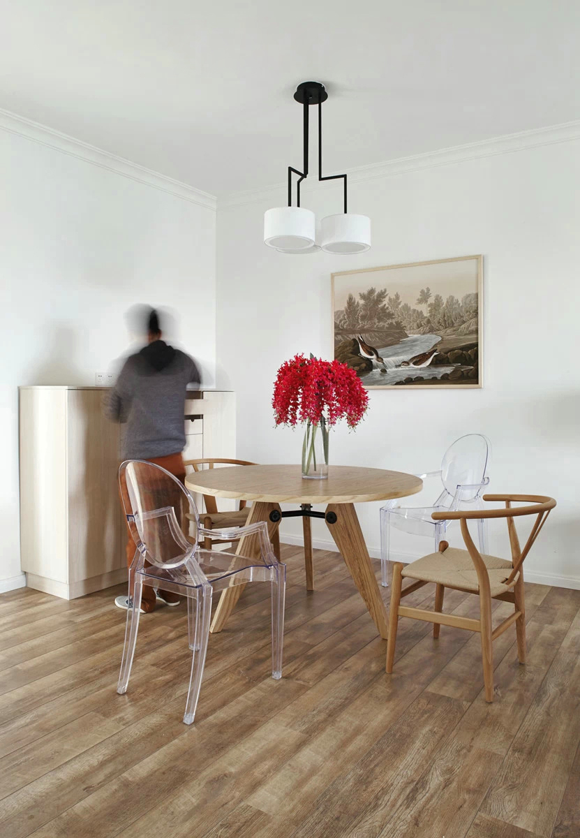 餐厅设计简单，木质餐桌椅让空间显得更加朴素，红色插花提升了空间质感。