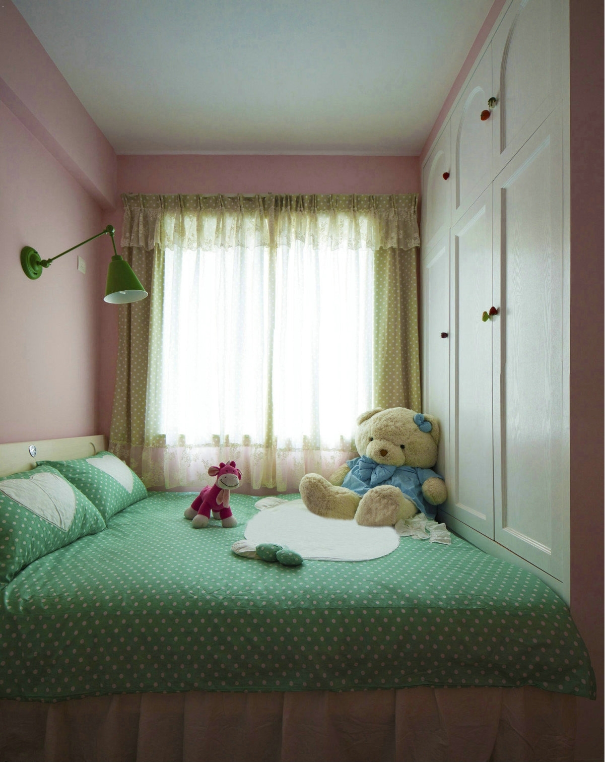次卧是小朋友的房间，粉色的墙壁，波点床铺，毛绒绒的小熊，处处透露着可爱。