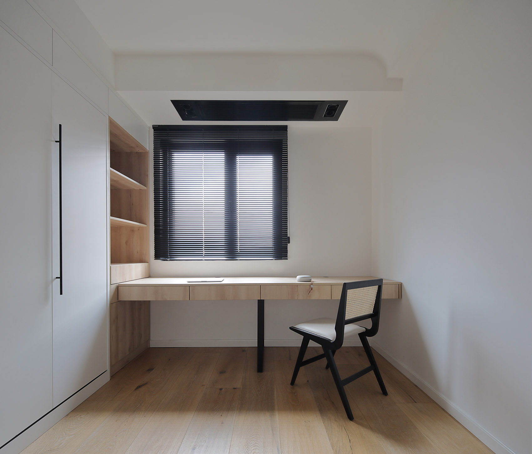书房空间使用了一体柜设计，在白色空间中，木质元素彰显出业主追求平静的生活状态。