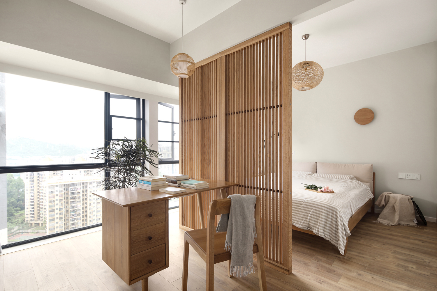 卧室采用白色和木色打造，巧妙运用隔断划分睡眠区和工作区，使得整个空间宽敞而舒适。