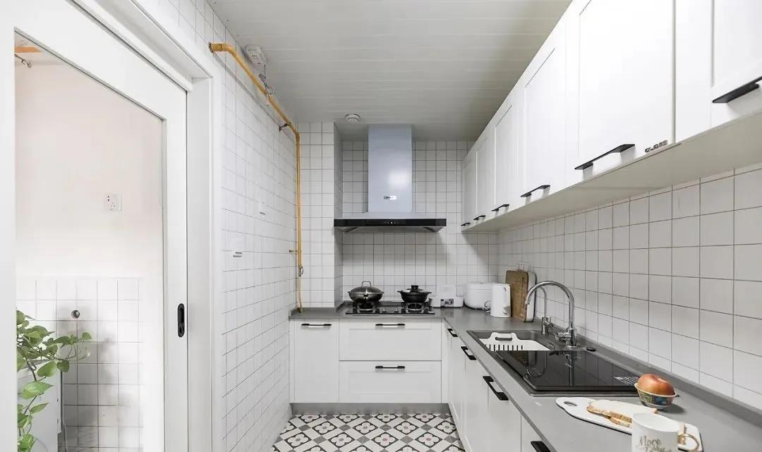 白色瓷砖铺贴营造整洁的气质，白色橱柜优雅大气，动线设计合理。