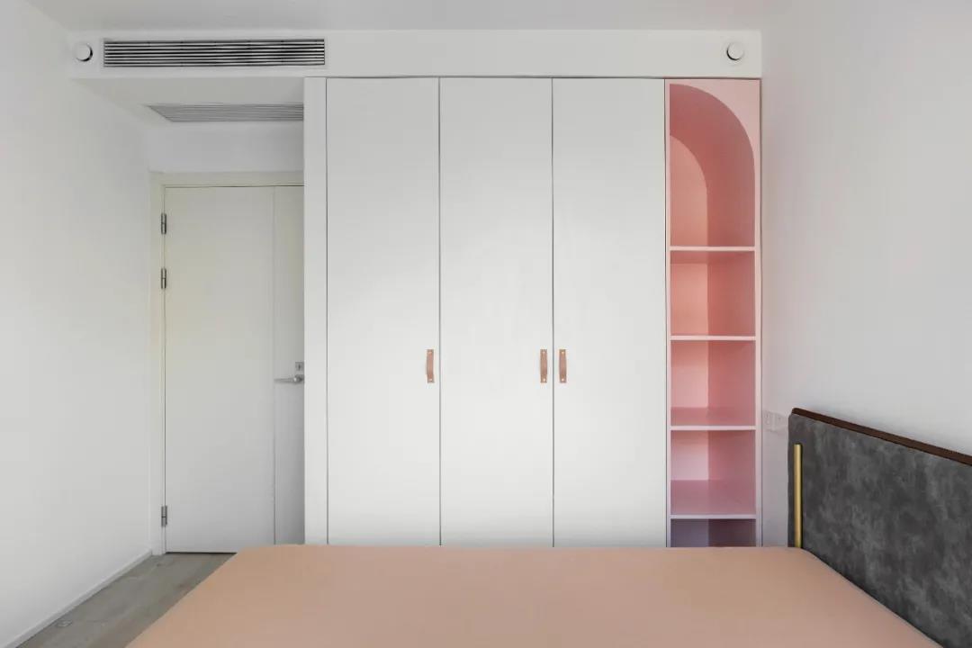 小的卧室沿用白粉配色法，嵌入式衣柜使视觉效果更加干净，形成温暖的卧室空间。 