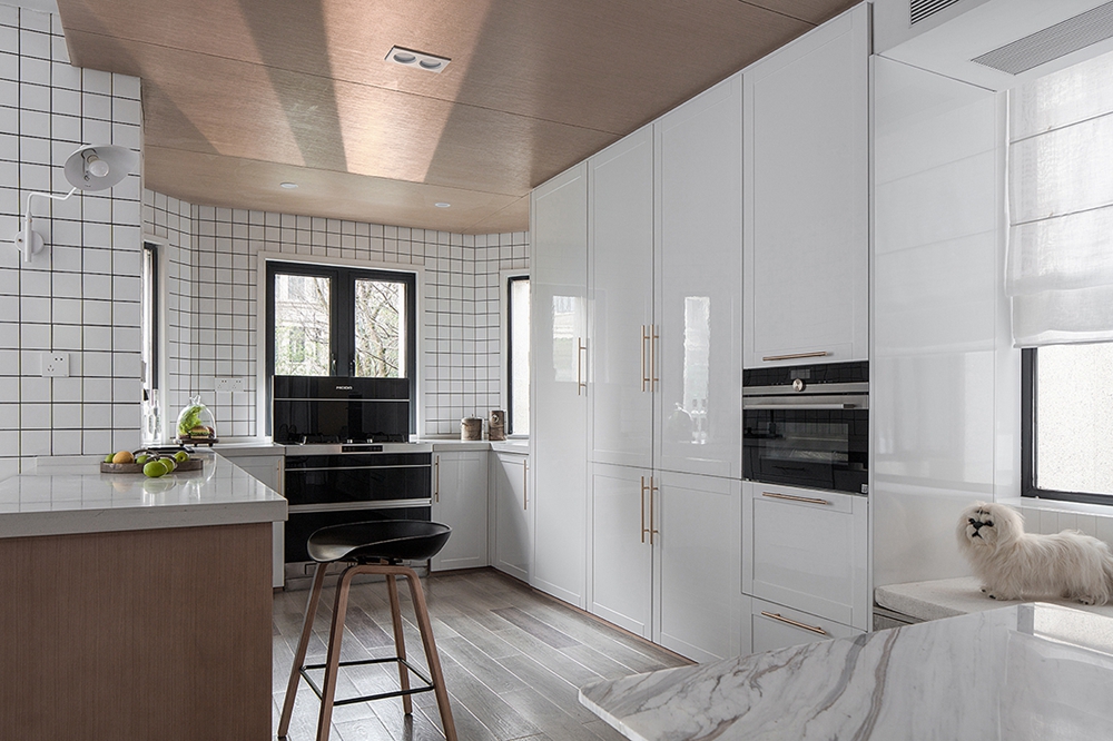 弧形厨房使空间更显大气，白色橱柜优雅大气，局部金色、黑色点缀，丰富了空间视觉。