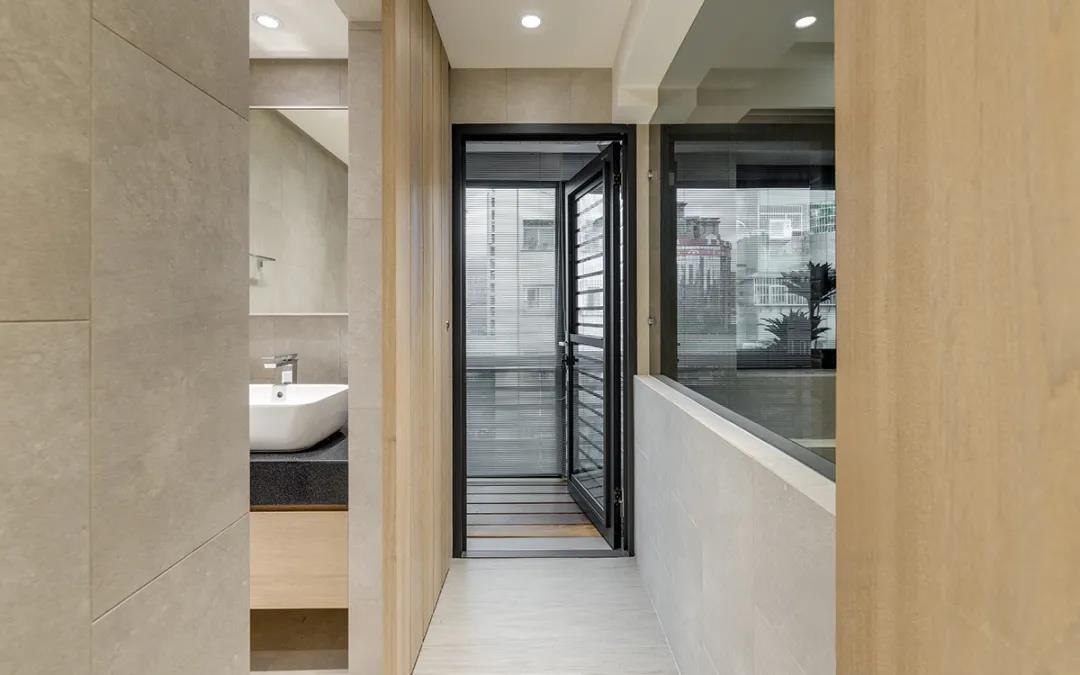 阳台与卫生间含有一个过道，空间选用木质背景墙和灰色地面相互碰撞，质朴而温柔。