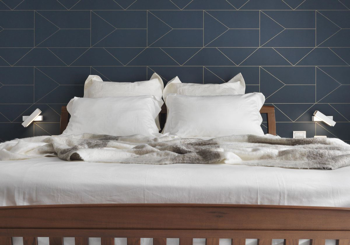 侧卧背景墙艺术感强，白色床品搭配木质床架，使侧卧空间更加简约温馨。