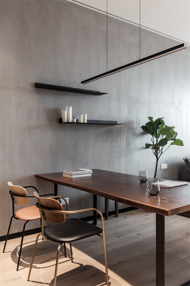 餐厅光线通透且明亮，大面积灰色背景搭配木质餐桌椅，传递着一种温暖感。
