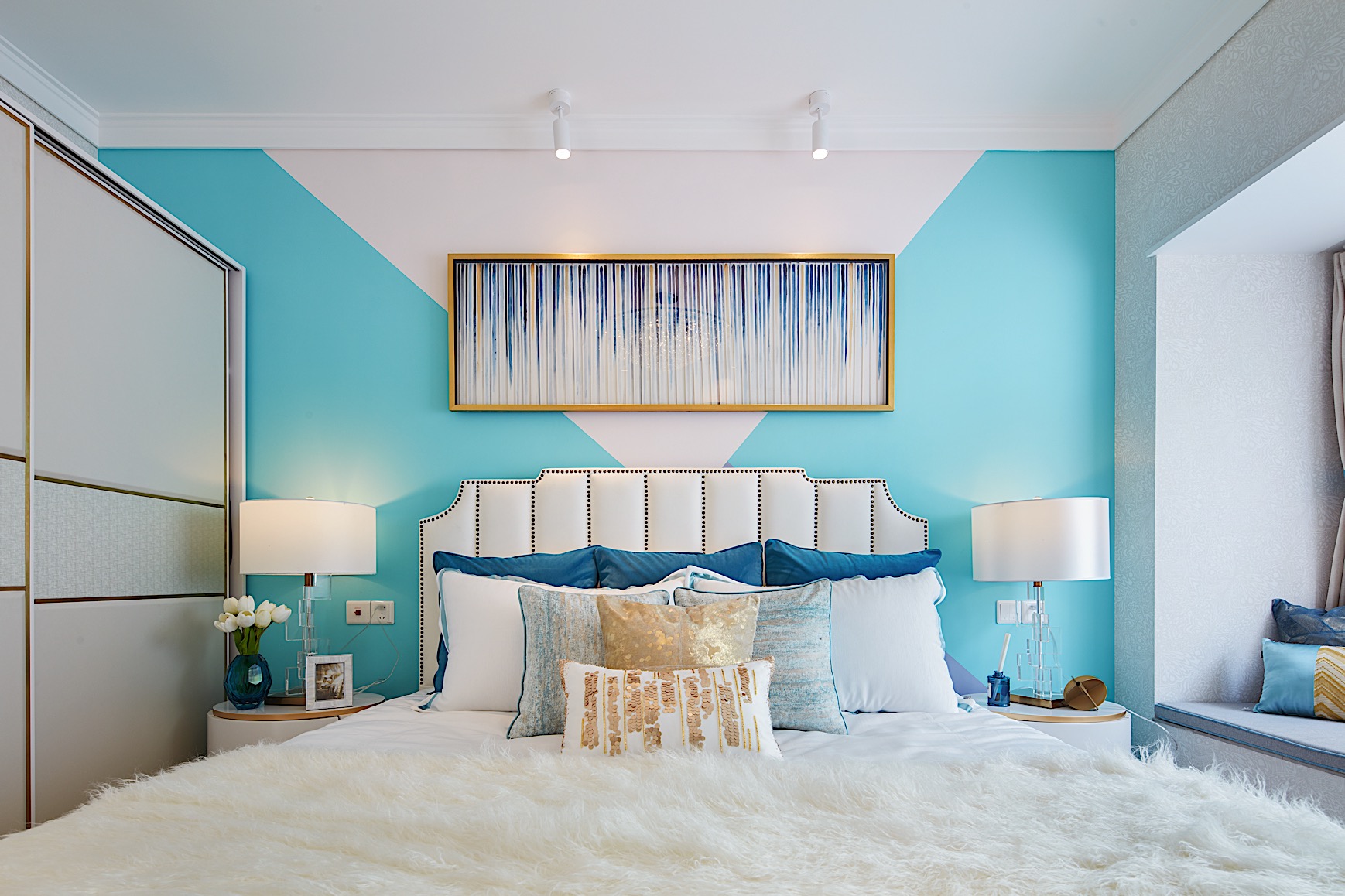 主卧背景墙采用蓝白色彩对比，搭配精致软装，创造出丰富而优美的视觉效果。