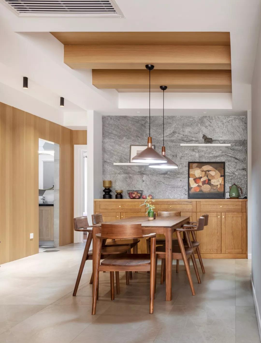 厨房墙面颜色偏灰色，餐桌椅搭配木质材料，为空间增加了温暖感。