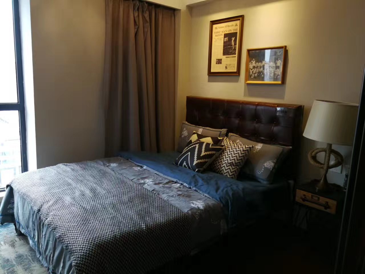 灰蓝色卧室床品让居室空间更为沉静，床尾小阳台借助采光，让卧室空间更为通透明亮。
