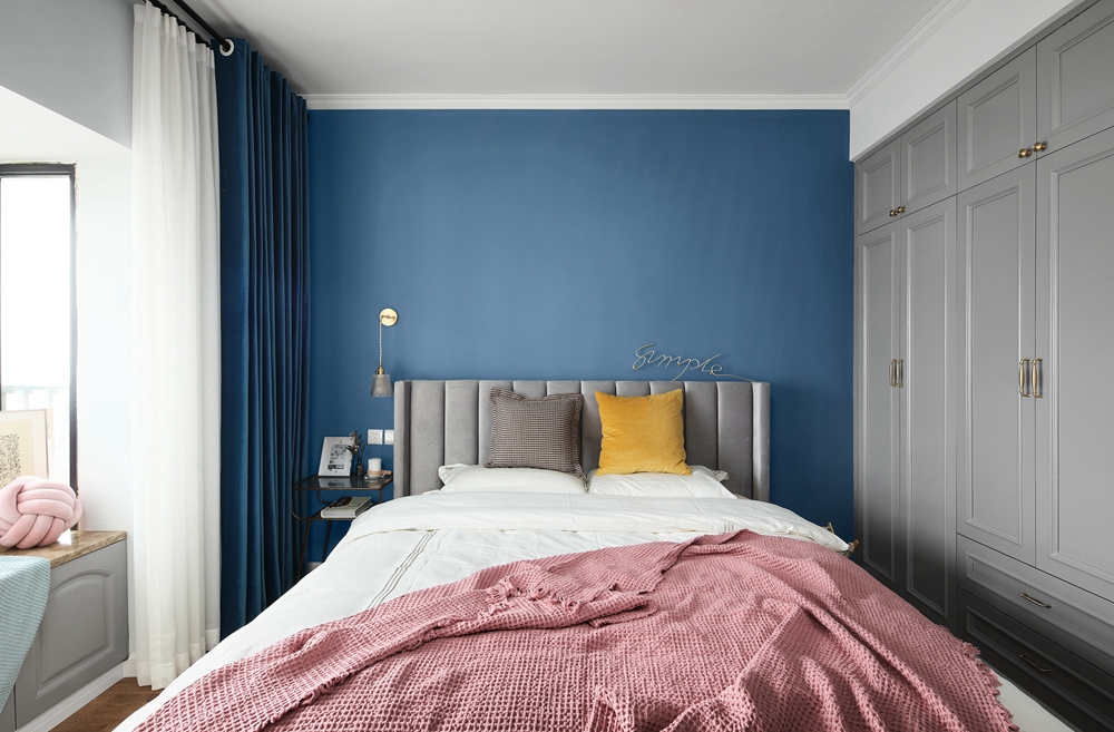 侧卧嵌入式灰色衣柜使空间变得竟然有素，蓝色调背景墙设计提升了时尚感。