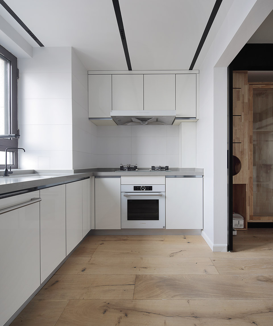 大量白色处理手法，再结合黑色的电器嵌入，强烈的颜色对比让厨房空间更具张力。