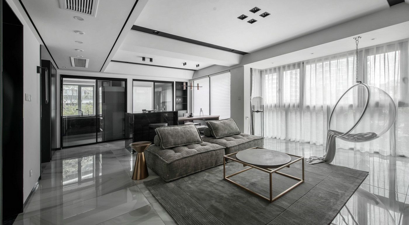 客厅与餐厅相连，沙发作为空间隔断，地毯色感高级，与沙发相互融合。