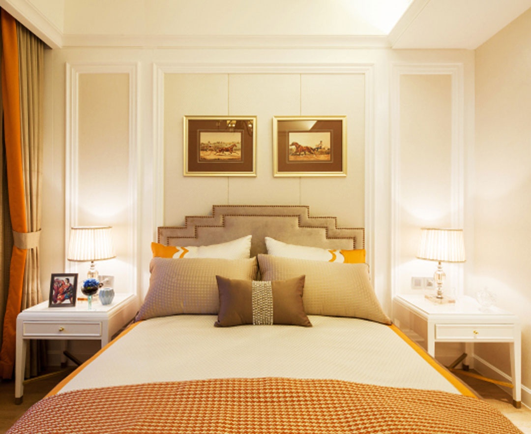 卧室采用米色护墙板设计，床头台灯对称放置，呈现出精致而生动的高端氛围。