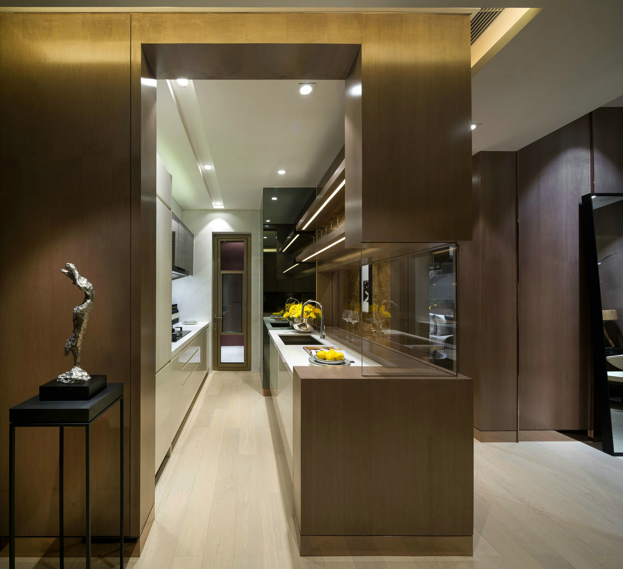 厨房空间简练不失高级感，在筒灯的照射下，米色橱柜温婉大气，空间明朗舒适。