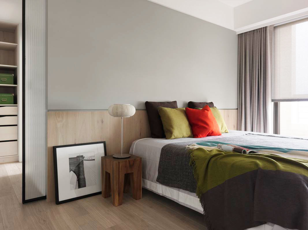 侧卧配色清新，灰色和木色背景墙营造温馨氛围，暖色床品提升空间温度感。