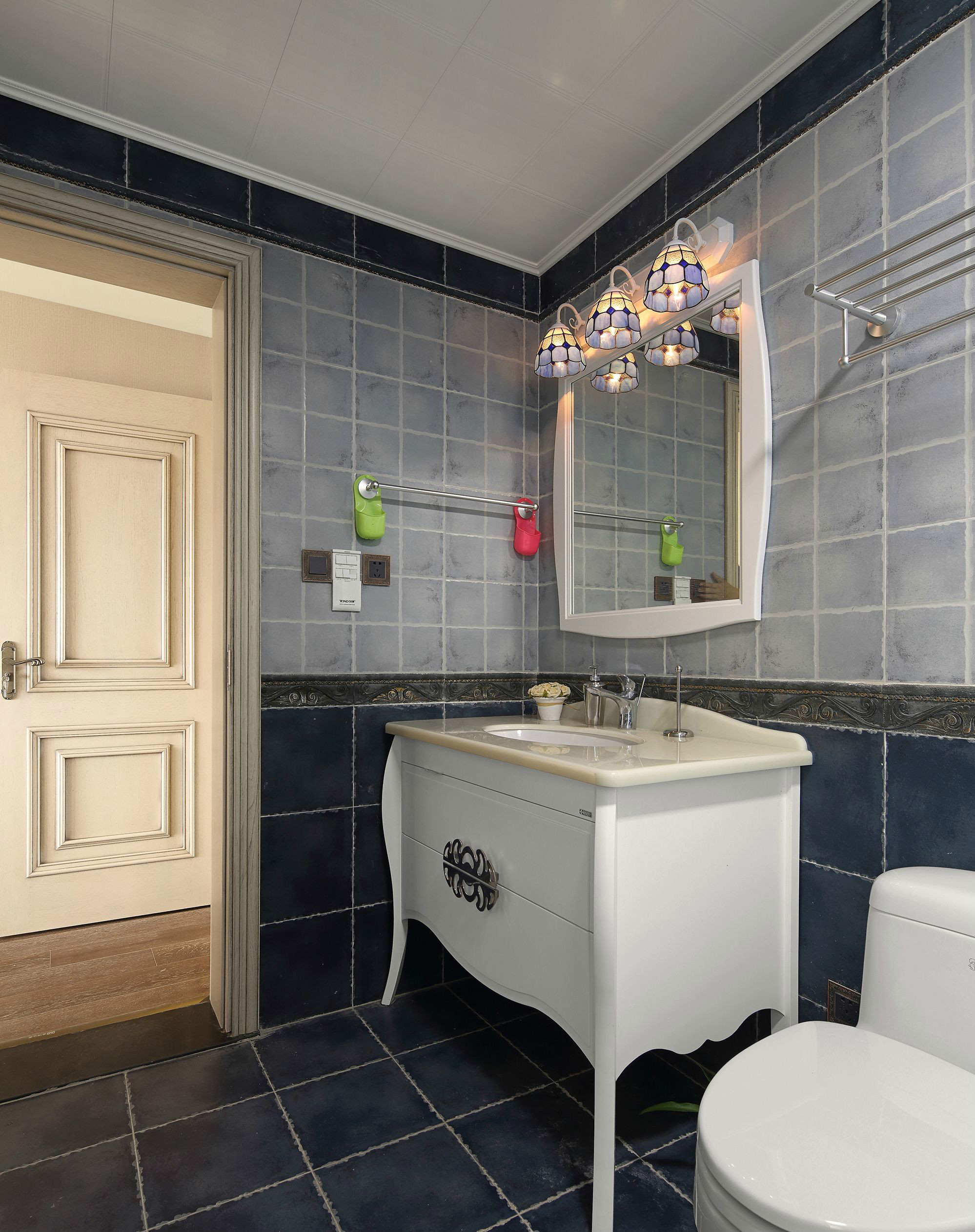 卫浴间采用深浅蓝色砖面铺贴，并搭配欧式洗手柜，呈现出典雅内敛的气息。