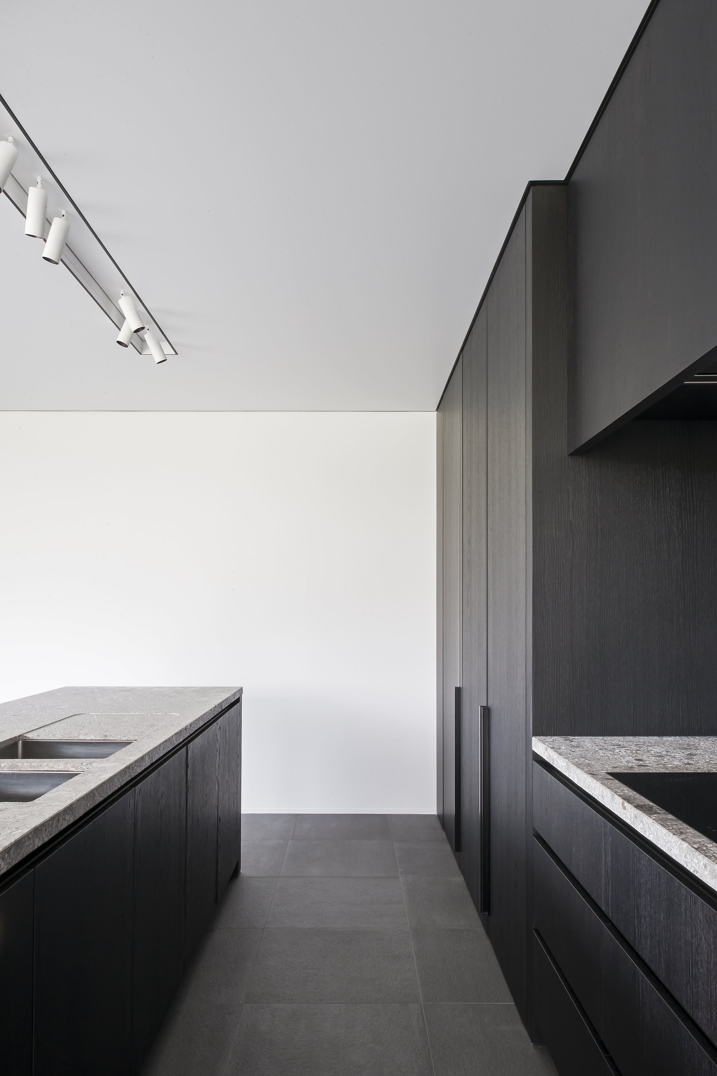 厨房配色利落，灰黑色橱柜搭配白色工作台，演绎着低调的现代风。
