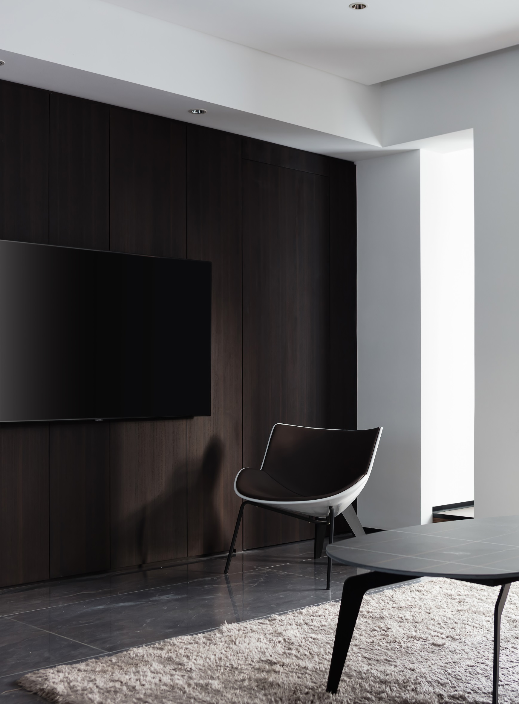 电视机背景墙宛若一位气质轩昂的绅士，黑色与木质色相结合，静谧优雅。
