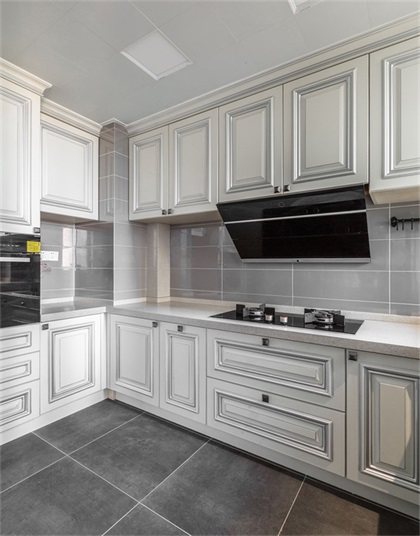 厨房以白色为基调，白色橱柜搭配灰色背景墙设计，体现出主人追求个性与精致的生活品味。