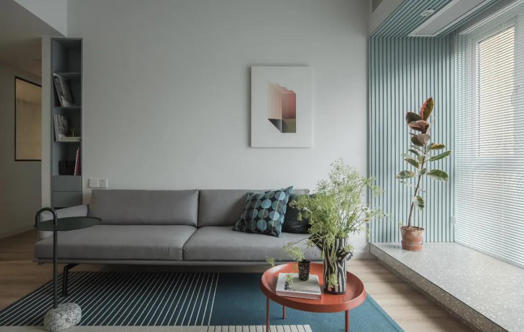 浅灰色的沙发设计让客厅空间充满了高级感，绿植点缀凸显慵懒的生活氛围。
