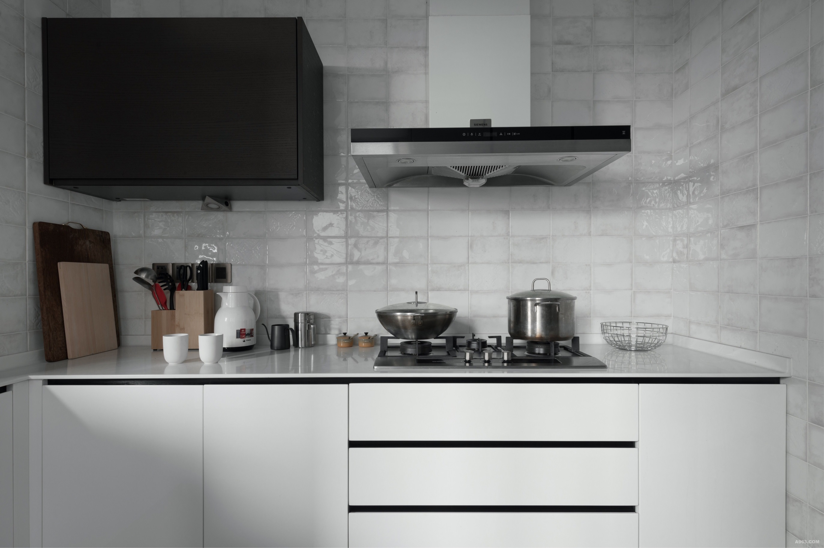 厨房空间整铺白色砖面，让空间延伸性更强，白色橱柜在空间中显得更加别致。