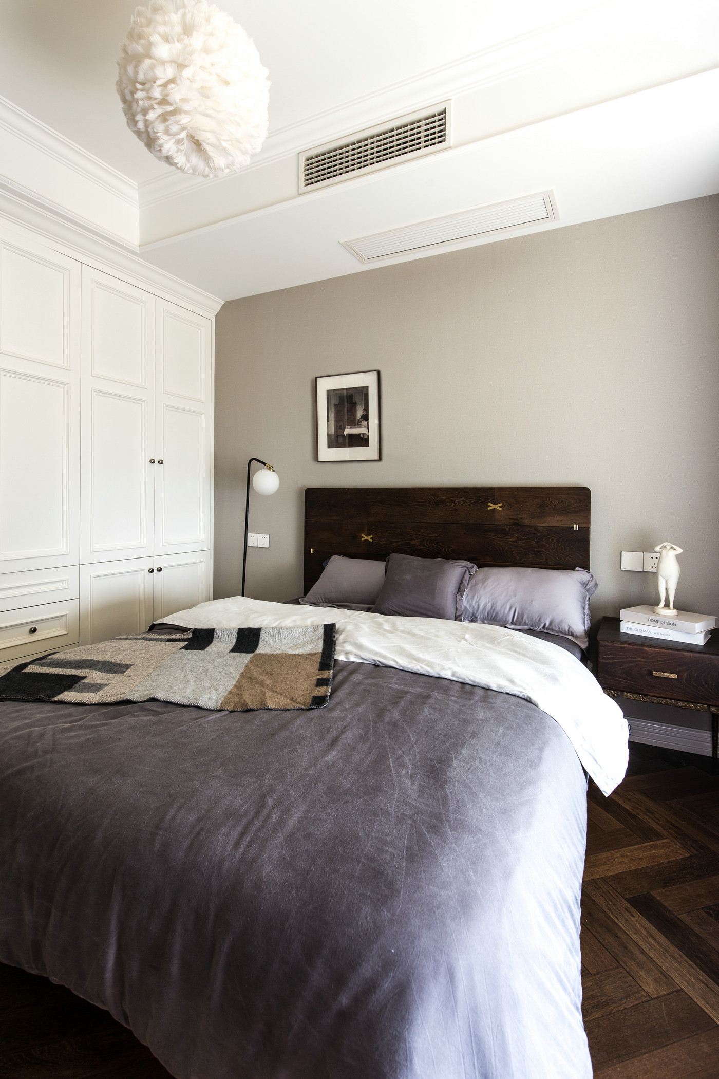 次卧使用深色的木质家具设计，暖色的墙面缓和了深木色带来的压抑。