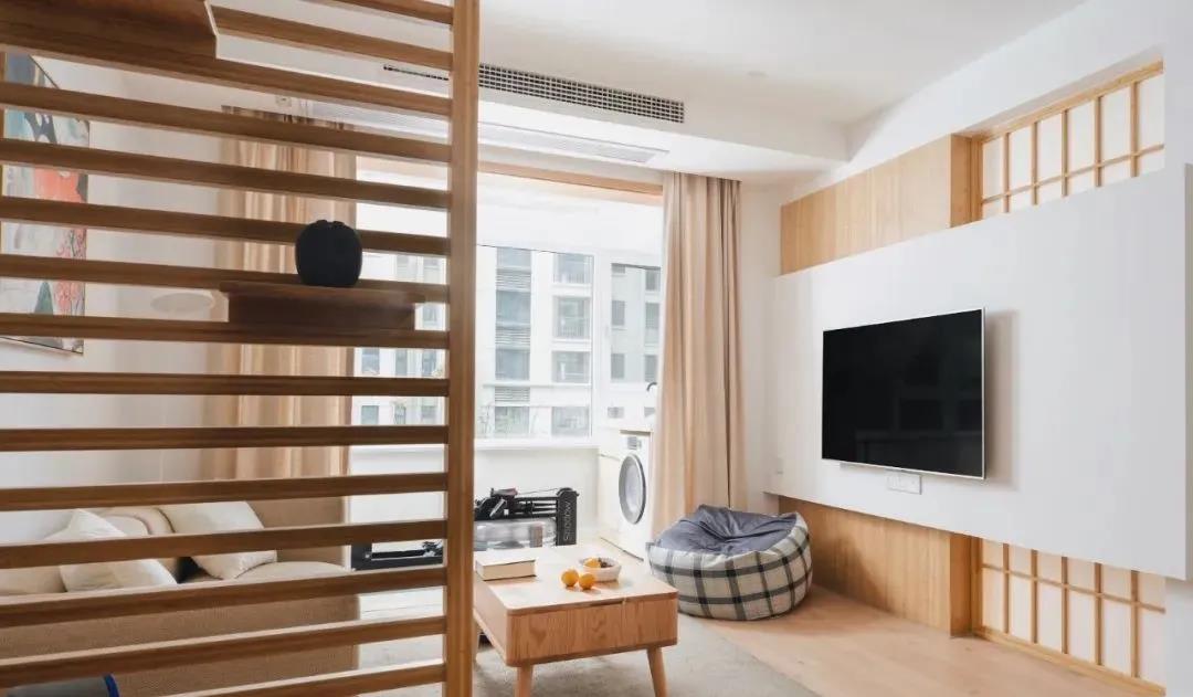 木质隔断增强了客厅的私密性，利用户型结构，背景墙设计坐落有致。