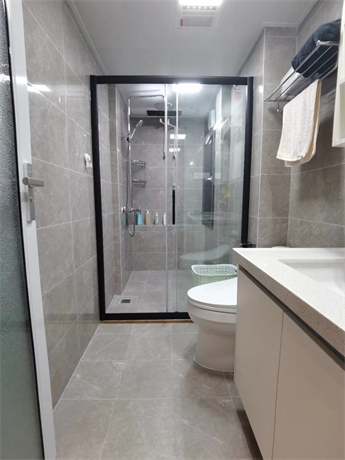 卫生间纵深较长，局部使用黑框玻璃作为干湿分离，白色洁具在米色空间中显得更加洁净。