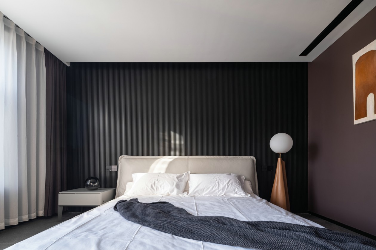 侧卧背景墙以黑色为主，家具设计上偏于现代氛围，彰显出舒适和惬意。