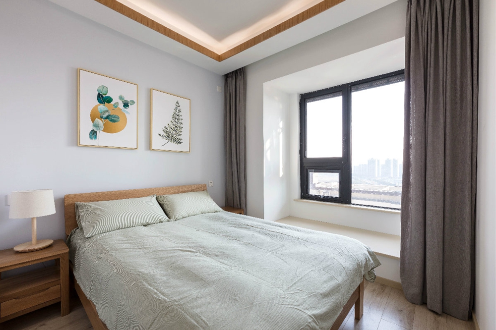 灰色作为卧室空间的背景，木色的床、浅绿色的床品，简单的搭配便提升了空间的活跃感与层次感。