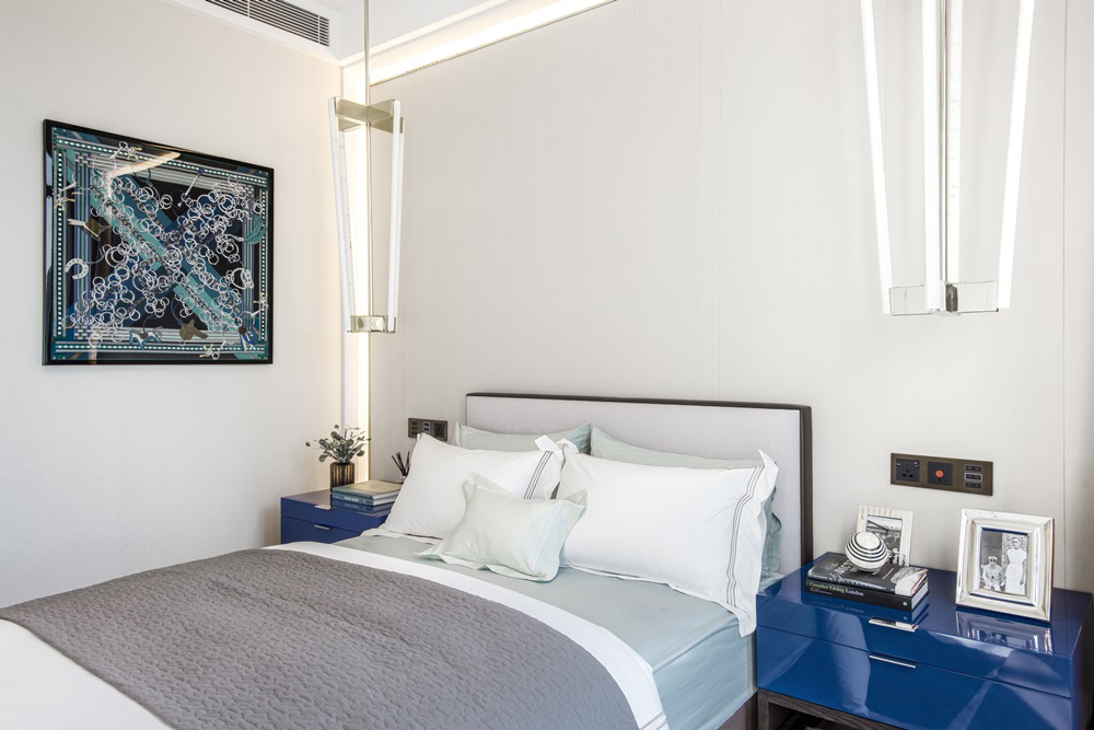 温暖的白色空间下，融入了具有个性的蓝色床头柜，在灯光的映衬下空间活力十足。