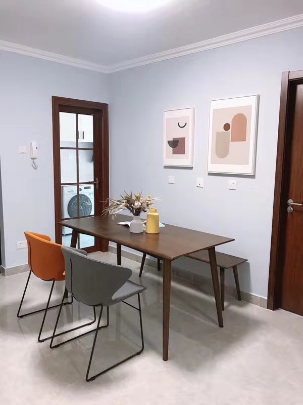 浅蓝色的墙面与木质餐桌椅相映成辉，配以时尚单椅，折射出静谧的用餐氛围。